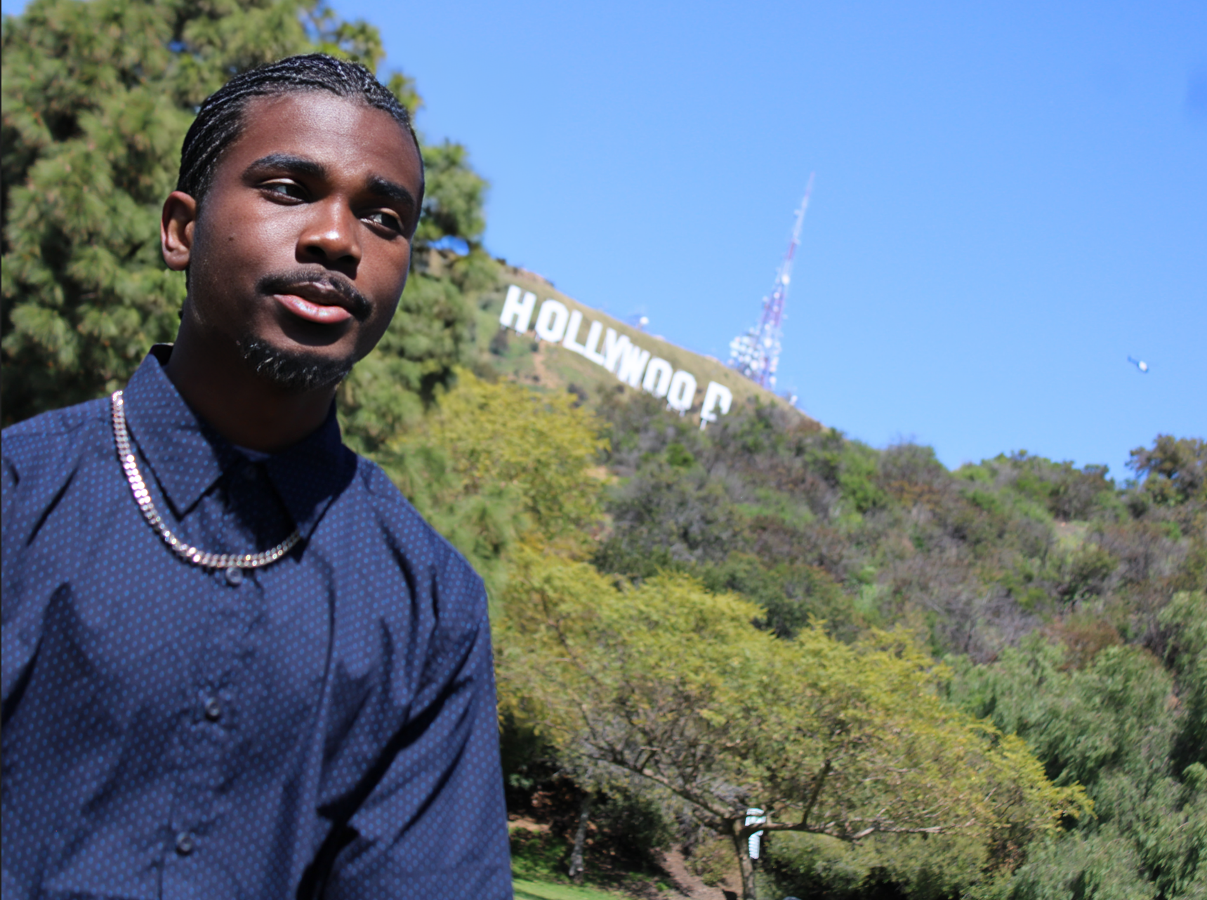 Jus Jasai-Independent rap artist in front of the iconic Hollywood sign on a video shoot location.